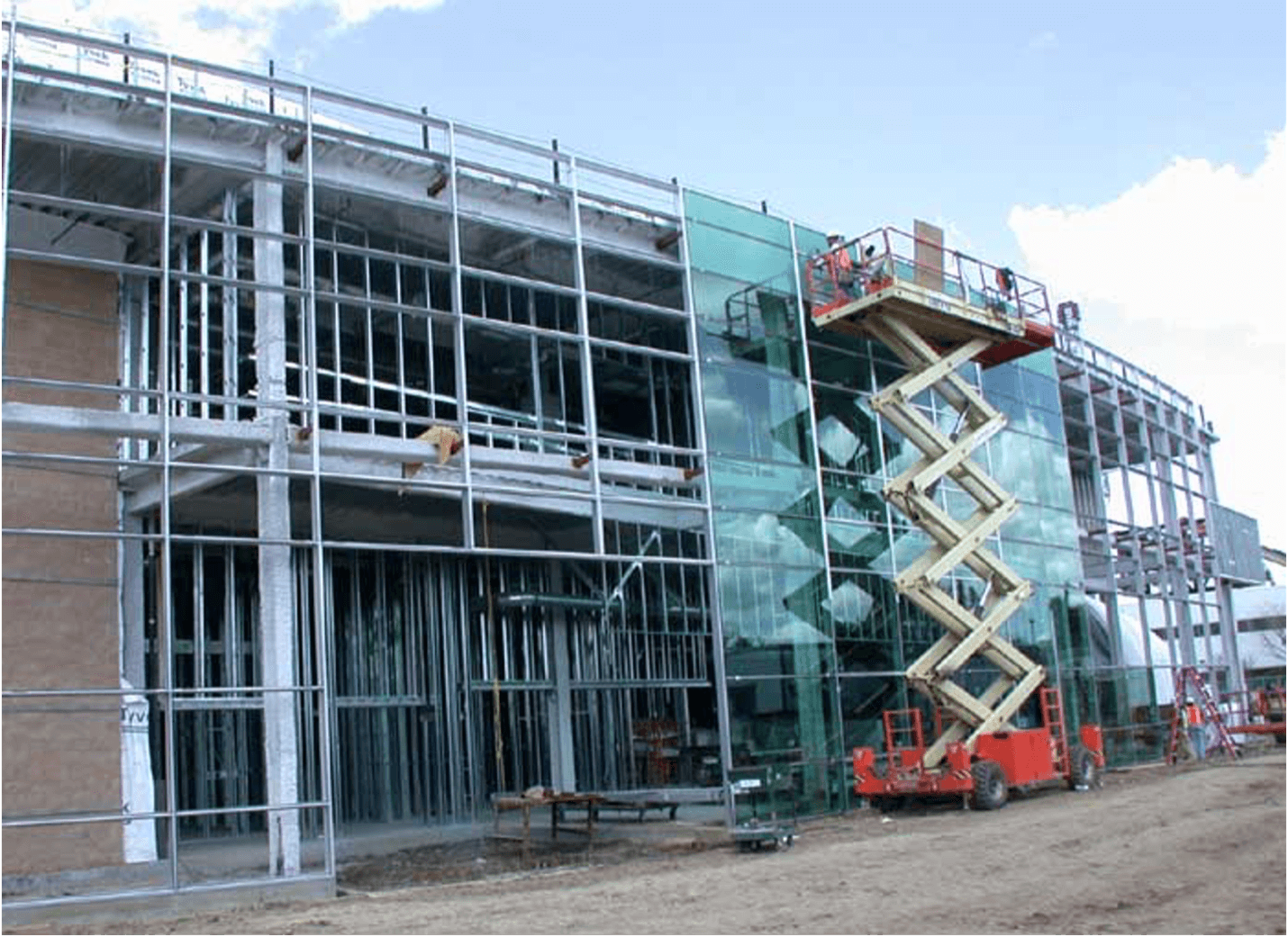 A team of glaziers installing a large window wall on a new construction home
